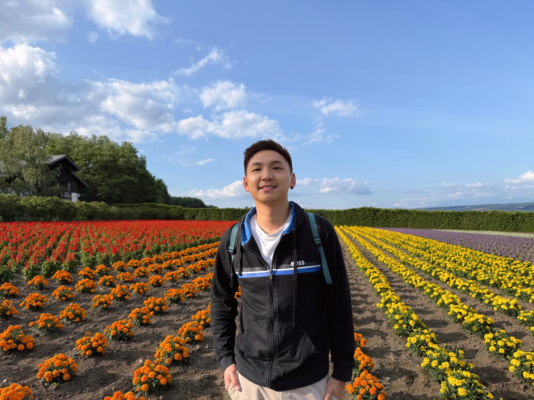 Alex en un campo de flores durante uno de sus viajes